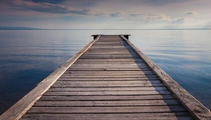  Worn-out wooden pier stretching over still waters, with subtle shadows of the weathered boar