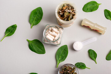 Homeopathic meds, capsules, green leaves and herbs from above. Homeopathic medicine top view. Homeopathy and alternative medicine.