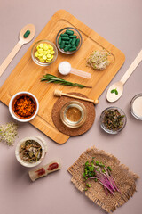 Homeopathy and alternative medicine. Meds, pills, capsules, supplements in small bowls on a wooden desk from above on a grey background. Top view homeopathic meds, flat lay still life.