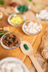 Homeopathy. Still life with wooden spoon with green pill and meds in rustic style. Homeopathic medicine. Alternative medicine.