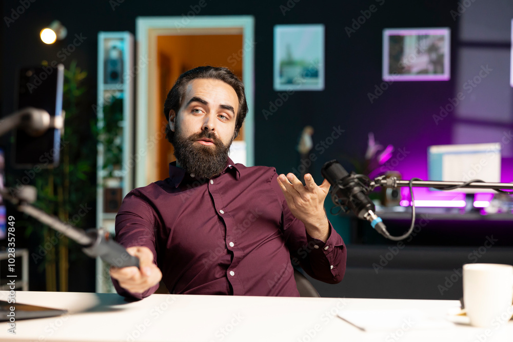 Aufkleber content creator talking in front on cellphone attached to selfie stick in studio, chatting with view
