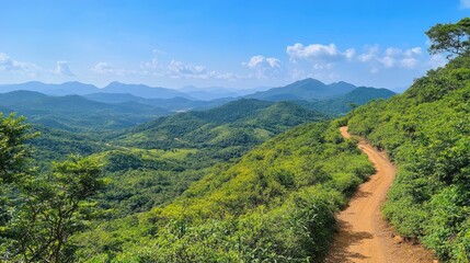 Obraz premium A beautiful mountain view with a winding trail cutting through vibrant greenery, under a clear blue sky, perfect for outdoor content