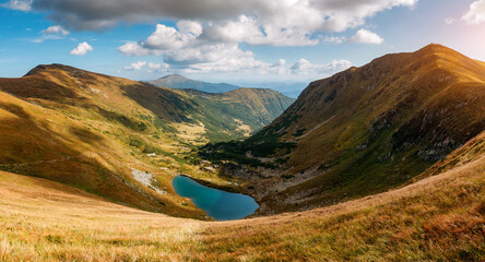 A magical view of the lake in a valley surrounded by high slopes. Carpathian mountains, National Park Chornohora, Ukraine, Europe.