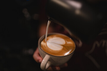 In bustling cafes, the barista crafted a hot drink, blending rich espresso and steamed milk into a...