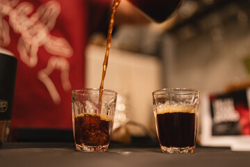 In a closeup of bustling cafes, the barista prepared a hot drink, the fresh aroma wafting through the air as bubbles danced in the steaming cup, inviting all to indulge.
