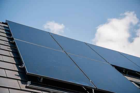 Solar panels installed under cloudy sky on rooftop