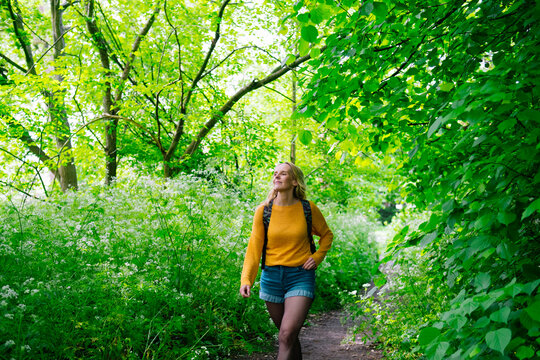 Mature woman walking amidst trees in garden