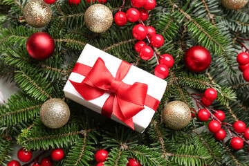 Christmas tree branches with balls, rowan and gift box, closeup