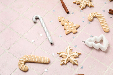 Composition with different Christmas cookies and decorations on color tile background