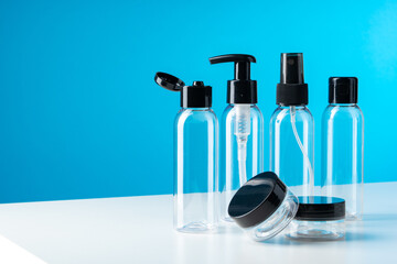 Plastic bottles with black caps are neatly arranged on blue background