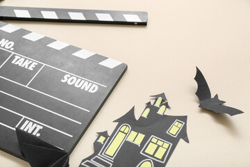 Naklejka premium Clapperboard with paper Halloween decor on beige background