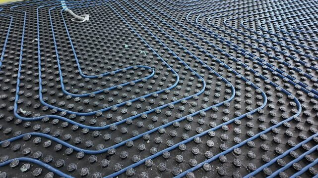 System of underfloor heating. Installation of a heat flooring system. Modern heating system in a new home