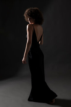 Woman wearing long black dress posing in studio