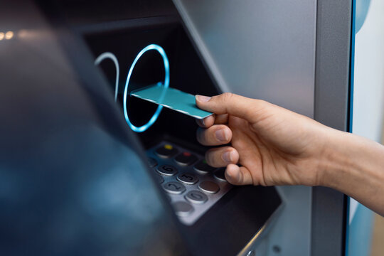 Hand of woman inserting card in ATM machine