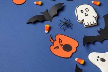 Composition with tasty candy corns, cookies and Halloween decor on blue background, closeup