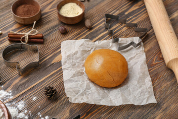Composition with raw dough, spices and utensils for preparing Christmas cookies on wooden background