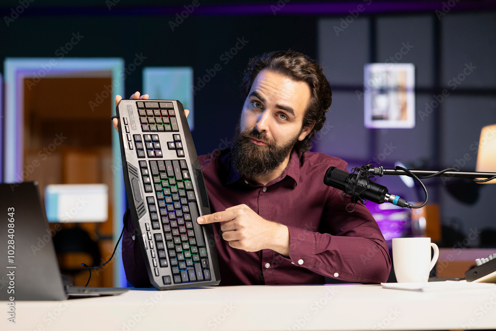 Poster influencer in studio reviewing gaming keyboard. online show host filming electronics haul, presentin