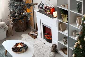 Interior of festive living room with Christmas decor, coffee table and fireplace