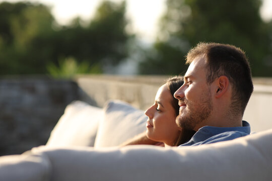 Couple contemplating sitting in a couch in a terrace