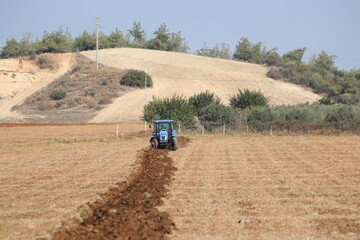 Obraz premium farmer plowing field in autumn