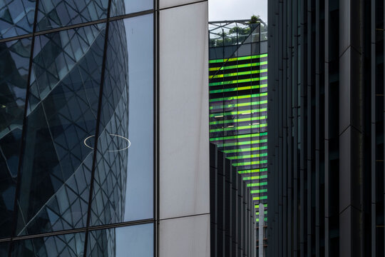 An artistic capture of futuristic urban design with reflective building elements creating an abstract interplay of colors, light, and shadow in the cityscape.