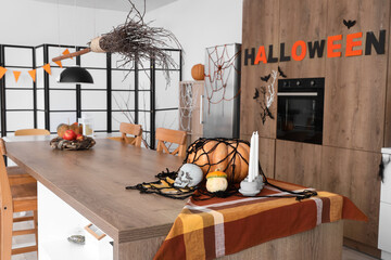 Interior of light kitchen decorated for Halloween with dining table