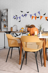 Interior of light kitchen decorated for Halloween with dining table