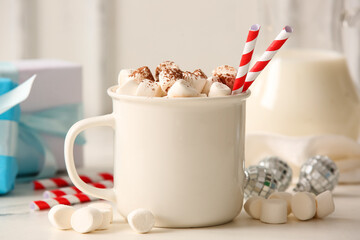 Cup of hot cocoa with marshmallows, Christmas balls and gift boxes on white background