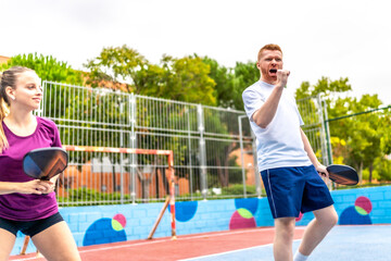Excited man raising fist celebrating pickelball point