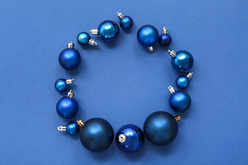 Composition with frame made of Christmas balls on blue background