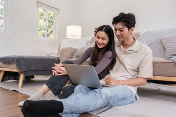 Fototapeta premium Young Couple Relaxing Together on Sofa with Laptop in Cozy Living Room, Enjoying Quality Time and Comfort at Home