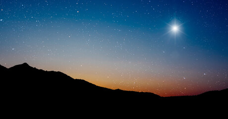 Christmas star shines at night over the mountains of Bethlehem
