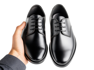Hand holding a pair of polished black formal shoes for men, sleek and professional, isolated on white background PNG transparent.