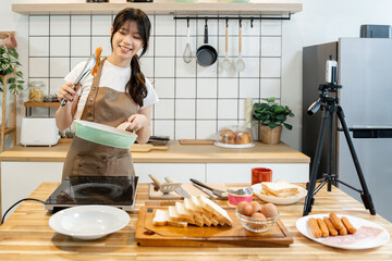 An Asian woman is making breakfast content for her followers.