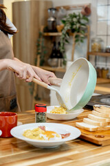 Asian woman making omelette for breakfast