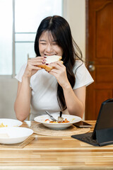 A happy Asian woman is having breakfast.