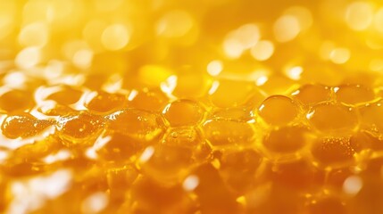 Close-up macro shot of golden honey dripping through a honeycomb, showcasing its rich texture and viscous nature.