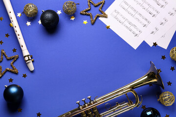 Flute and trumpet with Christmas decorations and notes on purple background