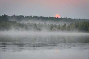 Sunrise with fog forming over a lake in Sweden, at dawn. Romantic silence