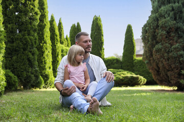 Fototapeta premium Father and his daughter spending time together on green lawn in park