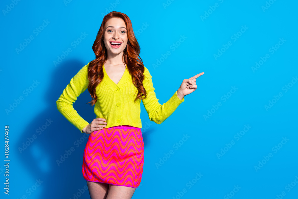 Canvas Prints Portrait of stunning young woman point finger empty space wear cardigan isolated on blue color background