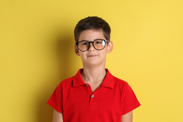 Portrait of cute little boy on yellow background