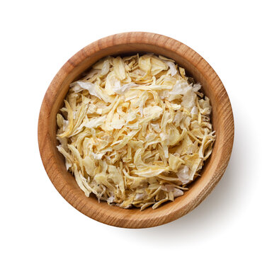 Dried onions in a wooden plate close-up on a white. Top view