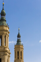 Two tall towers with green spires and gold tops