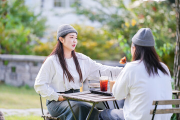A Korean man and a Japanese woman, both in their 30s and a married couple, are enjoying an autumn brunch with three dogs at a stylish cafe located in Gyeongchun-ro, Namyangju-si, Gyeonggi-do, Korea.