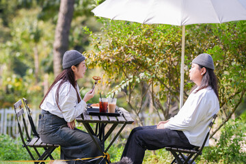 A Korean man and a Japanese woman, both in their 30s and a married couple, are enjoying an autumn brunch with three dogs at a stylish cafe located in Gyeongchun-ro, Namyangju-si, Gyeonggi-do, Korea.