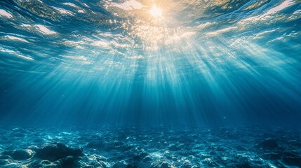 Naklejka premium 2410_135.a calm underwater world, viewed from below the surface, where sunlight gently filters through, illuminating the clear blue water with radiant light beams the surface above shimmers with soft