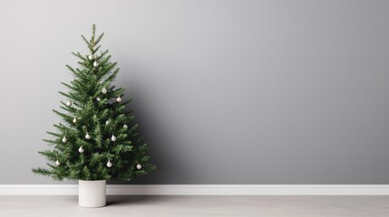 A beautifully decorated Christmas tree in a minimalist setting with a gray wall.