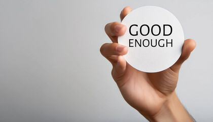 hand holding a card with good enough