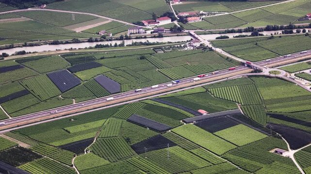 Loaded trucks with goods going on the highway. View from above, drone, birds point of view. 15 June 2024 - Trento, Italy.